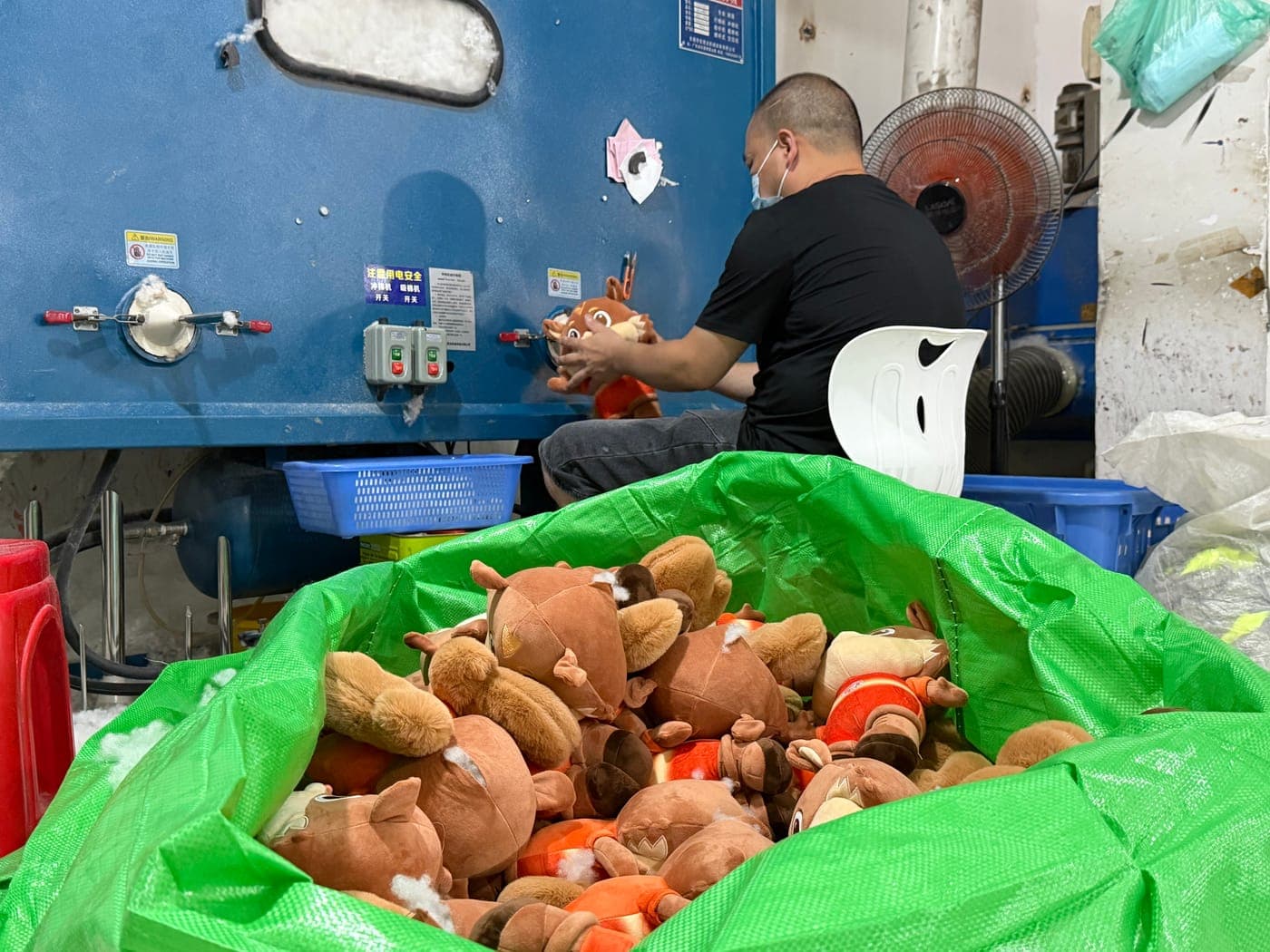 Custom plush toys being filled with soft polyester fiber at the factory