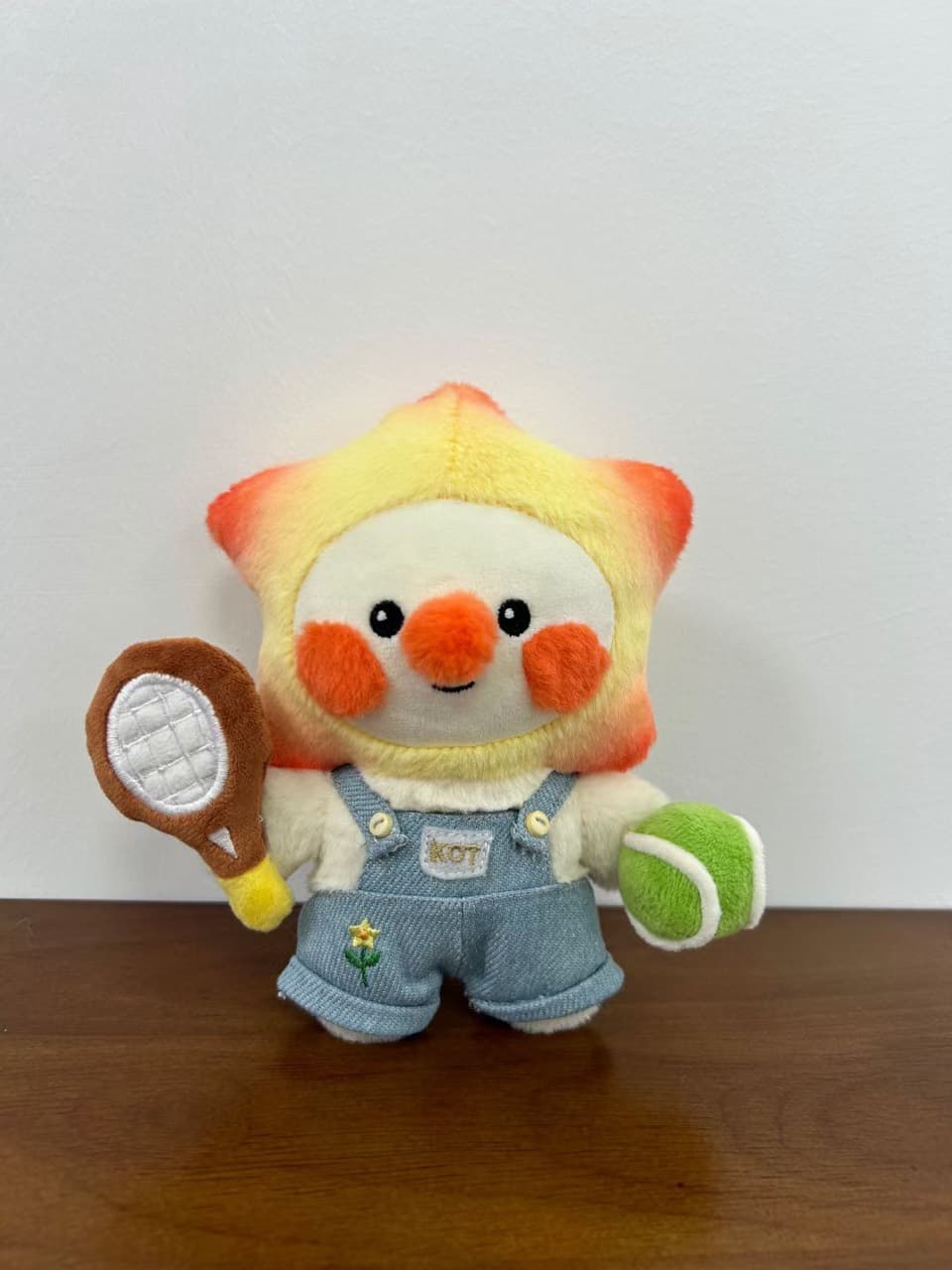 Star character plush toy with a tennis racket