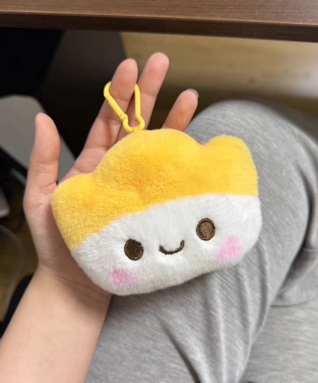 Dumpling-shaped plush keychain charm held in hand