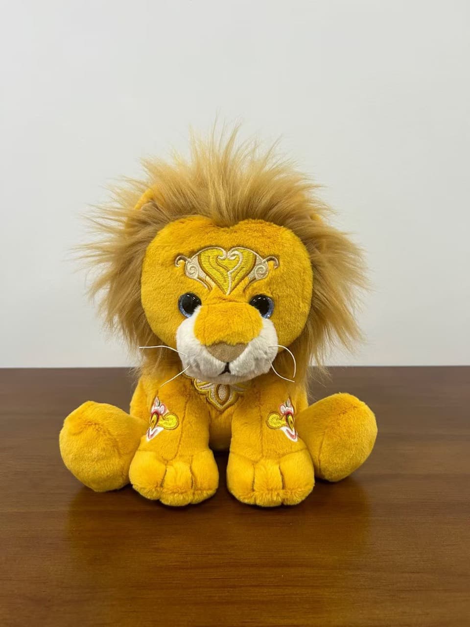 Golden lion plush toy with embroidered mane detail